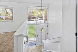 Foyer entrance with an inviting chandelier, a healthy amount of sunlight, and visible vents