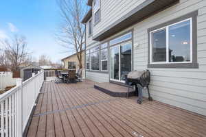 Deck with a storage shed, an outdoor structure, outdoor dining area, and area for grilling