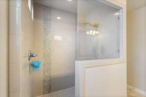 Bathroom with baseboards, walk in shower, and tile patterned floors