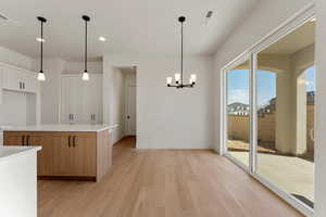 Kitchen featuring visible vents, recessed lighting, light countertops, light wood finished floors, and a notable chandelier