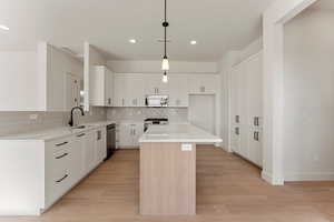 Kitchen with a sink, a center island, stainless steel appliances, recessed lighting, and decorative backsplash