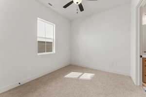 Empty room with baseboards, ceiling fan, light carpet, and visible vents