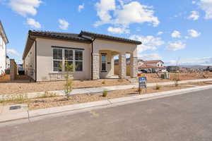 Mediterranean / spanish home with stucco siding, central AC, a tile roof, and stone siding
