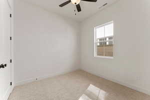 Carpeted empty room featuring baseboards, ceiling fan, and visible vents
