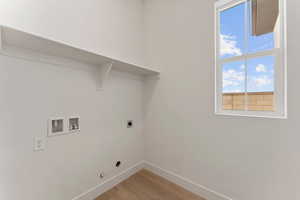 Clothes washing area featuring washer hookup, laundry area, light wood-style floors, baseboards, and hookup for an electric dryer