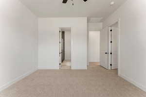 Unfurnished bedroom with baseboards, light carpet, and a ceiling fan