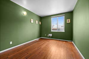 Unfurnished room featuring baseboards and wood finished floors