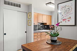 Kitchen featuring a sink, light brown cabinets, butcher block counters, and visible vents