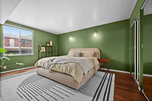Bedroom with wood-type flooring, baseboards, and a closet