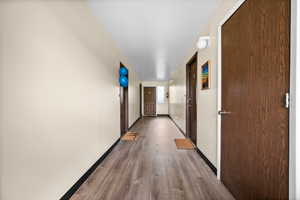 Corridor featuring baseboards and wood finished floors