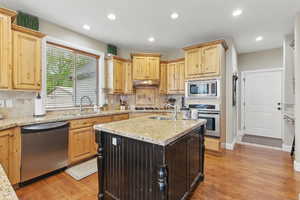 Kitchen with island, knotty alder cabinetry, granite countertops and hard wood oak flooring
