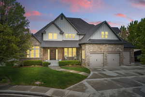 Craftsman-style house with board and batten siding, roof with shingles, a front yard, concrete driveway, and an attached garage
