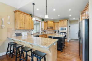Kitchen with island, knotty alder cabinetry, granite countertops and hard wood oak flooring