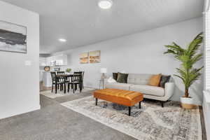 Carpeted living area featuring baseboards and recessed lighting