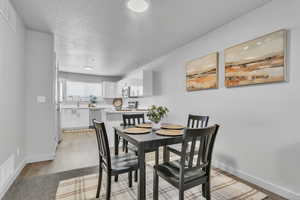 Dining area featuring visible vents, a textured ceiling, and baseboards