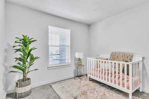 Bedroom featuring carpet flooring, baseboards, and a crib
