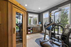 Workout area featuring crown molding, light wood finished floors, recessed lighting, baseboards, and visible vents