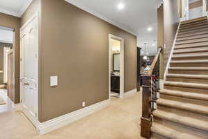 Stairway with recessed lighting, ornamental molding, carpet, and baseboards