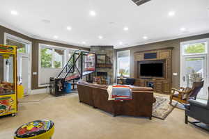 Living area featuring recessed lighting, light colored carpet, ornamental molding, and a fireplace