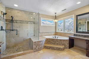 Bathroom with visible vents, a textured ceiling, a bath, and a tile shower