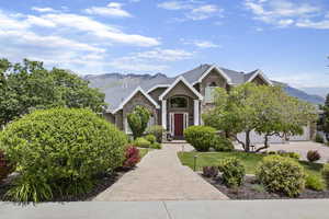 View of front of property featuring a mountain view, a front yard, and stone siding