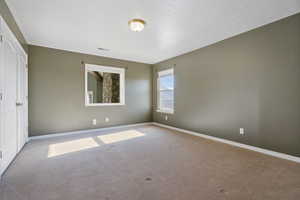 Spare room featuring baseboards, carpet flooring, and visible vents