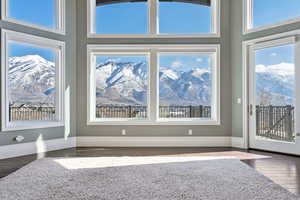 Interior space featuring baseboards, a mountain view, wood finished floors, and a high ceiling