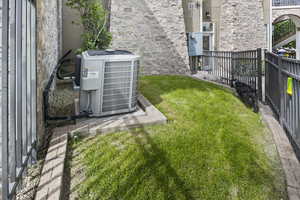View of yard featuring central air condition unit and fence