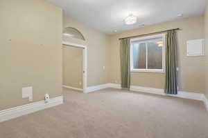 Spare room featuring baseboards and light carpet