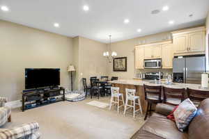 Living area with light carpet, a chandelier, recessed lighting, baseboards, and visible vents