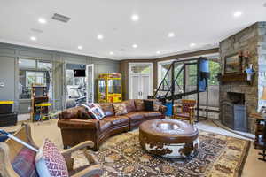 Living room featuring crown molding, recessed lighting, visible vents, and french doors