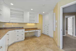 Kitchen featuring recessed lighting, open shelves, built in desk, and white cabinets