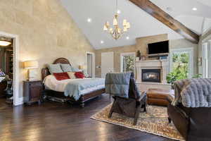 Bedroom with an inviting chandelier, multiple windows, hardwood / wood-style floors, and high vaulted ceiling