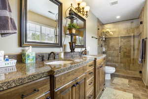 Full bathroom with a sink, double vanity, and visible vents