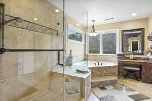 Bathroom with visible vents, tile patterned flooring, vanity, a bath, and a stall shower