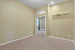 Empty room with light colored carpet, recessed lighting, and baseboards