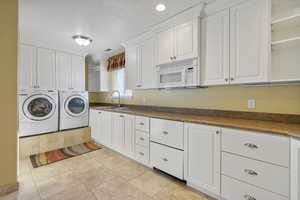 Laundry room featuring visible vents, a sink, cabinet space, independent washer and dryer, and light tile patterned floors