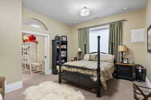 Carpeted bedroom with baseboards and visible vents