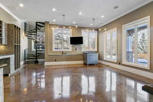 Unfurnished living room featuring crown molding, baseboards, stairs, and visible vents