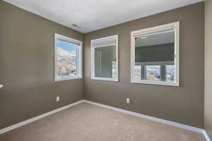 Carpeted spare room with baseboards and visible vents