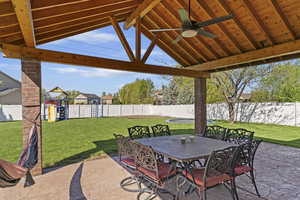 View of patio with outdoor dining area with ceiling fan and lighting