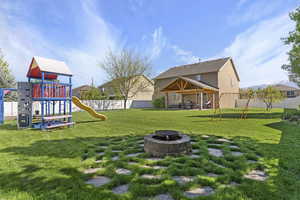 View of yard featuring a gazebo, an outdoor fire pit, fence, and playground