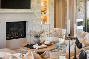 Living room with a glass covered fireplace and built in shelves