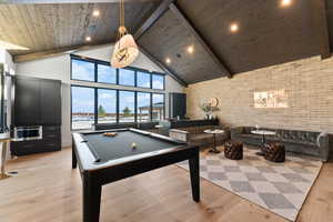Rec room featuring beamed ceiling, high vaulted ceiling, pool table, wooden ceiling, and light wood finished floors