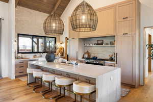Kitchen featuring light wood-style floors, stove, backsplash, and wooden ceiling