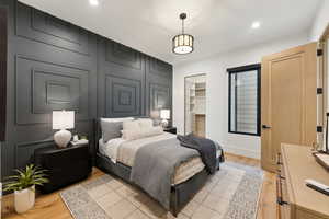 Bedroom featuring a closet, baseboards, a walk in closet, recessed lighting, and light wood-style flooring