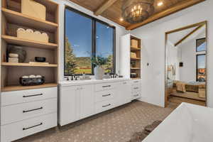 Interior space with a sink and vaulted ceiling with beams
