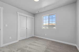 Unfurnished bedroom featuring baseboards, carpet, and visible vents