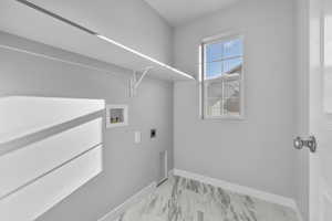 Clothes washing area featuring laundry area, marble finish floor, baseboards, hookup for a washing machine, and electric dryer hookup