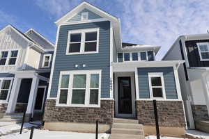 View of front facade with entry steps and stone siding